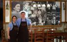 Ester Bravo y Xavi Teixeira, junto al cuadro de fotos antiguas de Las Pocholas e insignes clientes