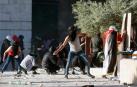 Jóvenes palestinos lanzan piedras a la policía israelí en la Explanada de las Mezquitas, en Jerusalén