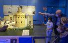 Varios visitantes contemplan la recreación del puerto de Sevilla en 1522, año en que la expedición regresó con 18 supervivientes a bordo de la nao Victoria