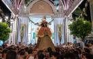 La virgen del Rocío, vestida de Pastora, procesiona a hombros de los almonteños por las calles de Almonte (Huelva).