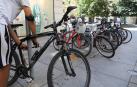 Un ciudadano pone el candado a una bicicleta en Pamplona