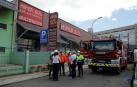 La fachada del edificio destruido por el incendio del día anterior y los técnicos que asesoran la condición de las instalaciones