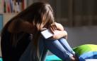 Una joven llora con su móvil en la mano