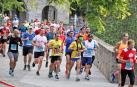 Un grupo de corredores en la San Fermín Media Maratón de 2019 cruzando el Portal Nuevo, una zona por la que volverán a pasar mañana los recorridos de La Media San Fermín