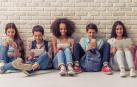 Los adolescentes sentados junto a sus amigos pero usando el móvil o la tablet en lugar de mantener conversaciones cara a cara