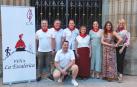 Fundadores y junta directiva de La Escalerica, junto a su logo, en la iglesia de San Lorenzo