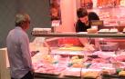 Un carnicero atiende a un cliente en la zona del mostrador del establecimiento donde se expone la carne de pollo
