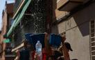 Lanzamiento de agua desde los balcones en una fiesta de agua celebrada estos días en Vallecas (Madrid)