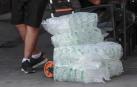 Un repartidor con varias bolsas de cubitos de hielo