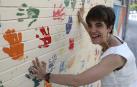 La pamplonesa Idoia Jorajuría Galetx, de 35 años, delante del mural de manos de colores del centro de educación especial Andrés Muñoz Garde, en Iturrama, donde imparte clase
