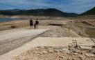 Una familia observa el nivel bajo del embalse de Rialb, en Lleina, que ha dejado al descubierto restos del antiguo pueblo de Tiurana
