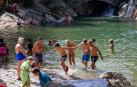 Varias personas se bañan en el río en Huarte a principios de agosto