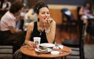 Una mujer, comiendo una cafetería