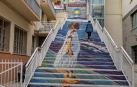 Las escaleras decoradas por un mural y, al fondo, el ascensor que salva su desnivel