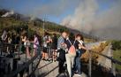 Vecinos de Ansoáin siguen el incendio en el monte Ezkaba ayer por la tarde desde la pasarela que cruza la Ronda Norte (fue cerrada al tráfico)