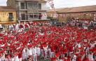 Los asistentes al lanzamiento del cohete de las fiestas de San Miguel de Cortes alzan sus pañuelos tiñendo de rojo la plaza del Ayuntamiento.