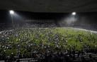 Espectadores en el terreno de juego tras ser suspendido el partido