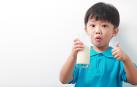 Un niño desayuna un vaso de leche