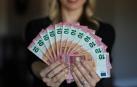 Una mujer muestra varios billetes de 10 euros