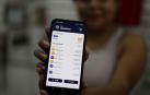 Una mujer muestra su billetera digital