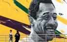 Unas mujeres pasan delante de un mural que representa al exjugador brasileño Edson Arantes do Nascimento, "Pelé" enfrente del estadio Al Khalifa de Doha, Catar