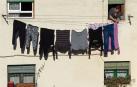 Una mujer tiende la ropa al sol en Estella.