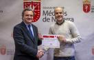 El cirujano Íñigo Calvo (derecha) recibe la beca de la mano del presidente del Colegio de Médicos de Navarra, Rafael Teijeira.