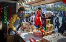 Uno de los comerciantes atiende a varios clientes en la Feria de Navidad