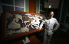 Jorge Garrido posa junto al cuadro del Guernica elaborado con chocolate en el obrador Galleros Artesanos de Rute (Córdoba)