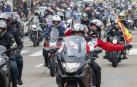 Motoristas participan en el desfile de banderas y antorchas, en el que se homenajea a los moteros fallecidos, por las calles de Valladolid