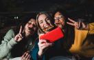 Unos adolescentes comen pizza mientras se hacen un selfie