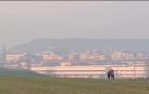 Estampa de la ciudad de Pamplona desde las afueras, velada por un ligero humo