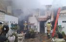 Efectivos de bomberos trabajan en la vivienda incendiada