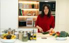 Adriana Oroz Lacunza, @adristylelife en instagram, corta verduras en la cocina de su casa.