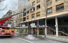 Bomberos de Navarra con un camión escala sofocan el incendio en una vivienda de la calle Iturrama de Pamplona.