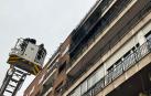 Bomberos frente a la fachada incendiada