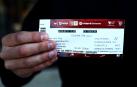 Uno de los aficionados sujeta la entrada para el Athletic-Osasuna de la vuelta de la semifinal de la Copa del Rey.
