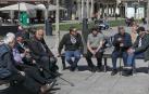 Dos grupos de hombres charlan al sol en la Plaza del Castillo de Pamplona