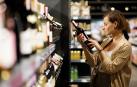 Una mujer, mirando el etiquetado de una botella