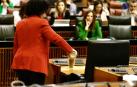 La diputada del Grupo Mixto Maribel Mora derrama arena en el escaño del presidente de la Junta, Juanma Moreno, durante el pleno del Parlamento andaluz donde se debate una proposición de ley del PP y Vox para reordenar los regadíos de la Corona Norte de Doñana