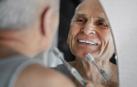 Un hombre observa en el espejo los efectos en sus dientes tras cepillárselos