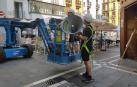 Dos operarios trabajan en la colocación de la megafonía en la plaza del Ayuntamiento de Pamplona