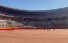 Los areneros riegan la arena de la plaza de toros antes de la corrida del 9 de julio