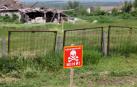 Una señal de ''¡Precaución! Minas'' en la zona de pruebas de una máquina de desminado humanitario construida sobre la base de un tractor T-150 por ingenieros de Kharkiv, región de Kharkiv, noreste de Ucrania.