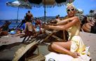 ‘GLAMOUR’ QUE RESPIRA VERANO  Me maravilla el estilo de Grace Kelly aplicándose crema solar bajo el sol abrasador del Mediterráneo en la Riviera francesa. ‘Glamour’ personificado el que destila en ‘Atrapa a un ladrón’, dirigida por Alfred Hitchcock en 1955, y en la que interpreta a una rica heredera que disfruta de sus vacaciones de verano con su madre. Entre baños de sol y sal, se cruza en su vida un seductor Cary Grant, en este caso ladrón de joyas ya retirado de su ‘oficio’ que debe demostrar su inocencia. La acción transcurre en lujosos hoteles, casinos y paisajes espectaculares y entre los dos protagonistas, claro está, saltan chispas. Una película que, aunque es considerada de tono menor, más romántica que de intriga, dio un giro copernicano a la vida de la estrella del celuloide, una de las actrices favoritas del mago del suspense.  Durante el rodaje, Grace Kelly conoció al príncipe Rainiero de Mónaco que, un año después, se convertiría en su marido. El resto ya es historia.