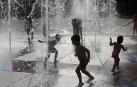 Una imagen refrescante de niños bajo unos chorros de agua en la plaza Yamaguchi