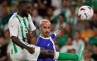 El delantero del Atlético de Madrid Antoine Griezmann centra el balón junto a Youssouf Sabaly, del Betis