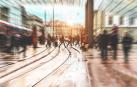 Personas caminando por la zona de vías de un tranvía en una ciudad