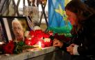 Una mujer enciende una vela frente a un retrato del jefe de los mercenarios de Wagner, Yevgeny Prigozhin, en un monumento improvisado en Moscú, Rusia