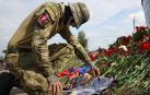 Un mercenario deja flores frente a las oficinas de Wagner en San Petersburgo en recuerdo de Prigozhin